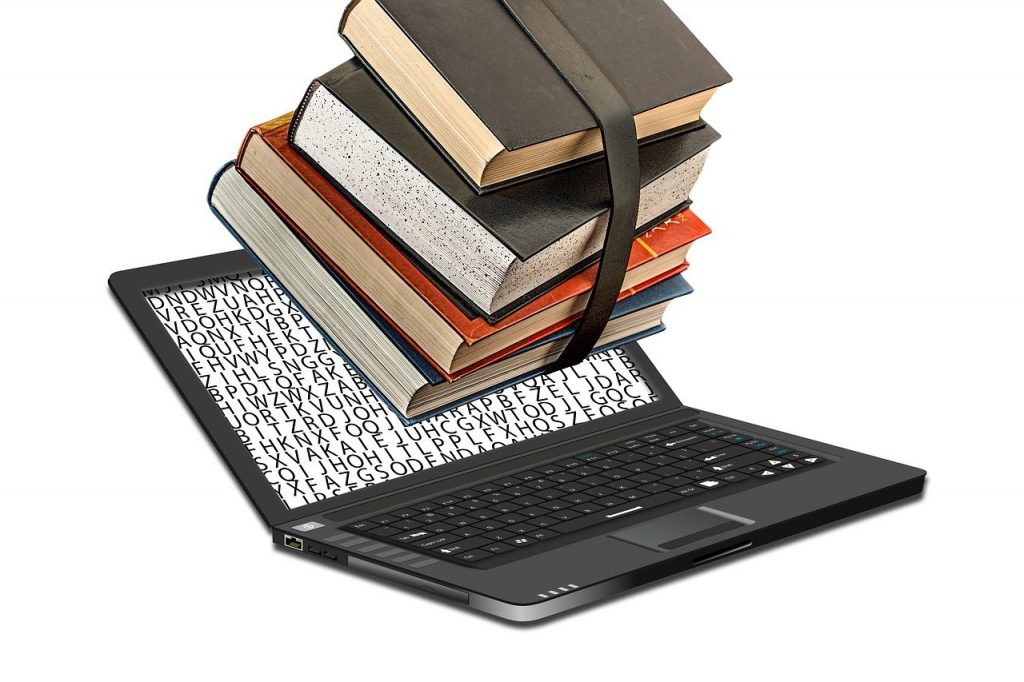 ebook formatting sofrware - image shows print books being pushed into a laptop