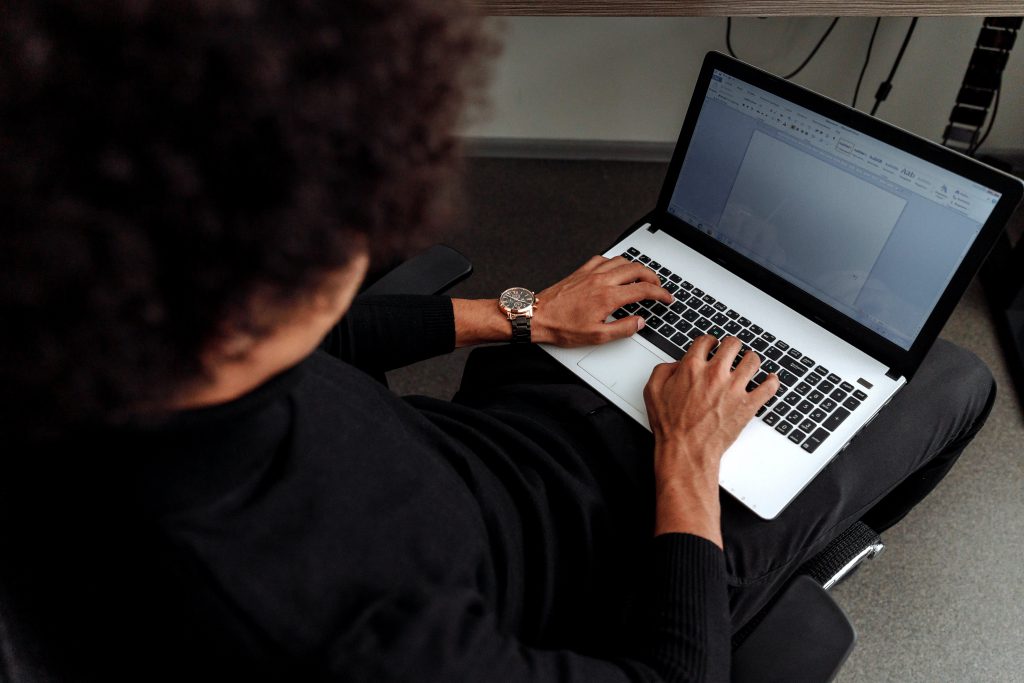 Author inquiring about the advantages of selling ebooks on his own website with man sitting with his laptop on his lap